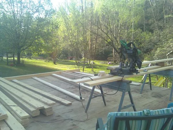 Miter saw and framing lumber on a deck under construction in Providence